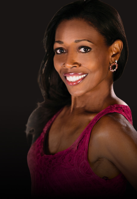 In the image, there is a content and joyful woman with a warm and genuine smile on his face. 