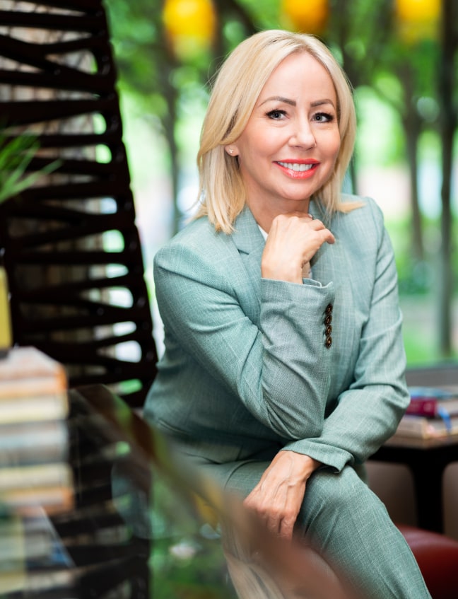 Photo of Dr. Schindler smiling while wearing her green suite