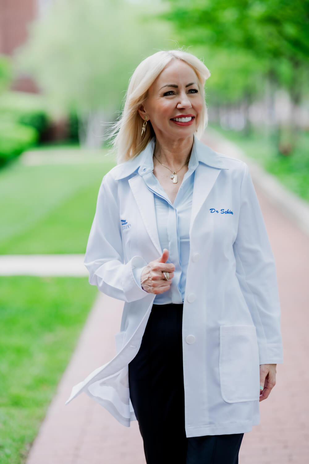 Dr. Schindler smiling with her awards by her side.