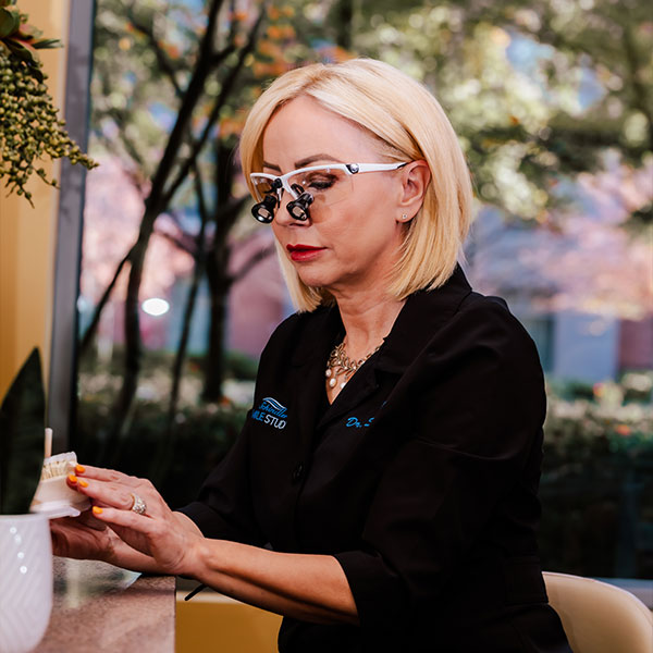 Dr. Schindler smiling with her awards by her side.